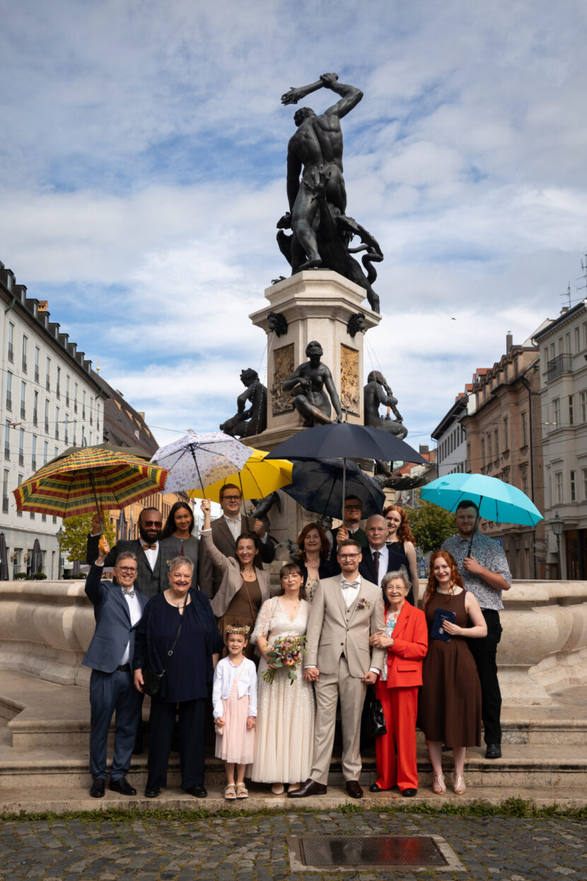 Hochzeitsgesellschaft mit Regenschirmen in Augsburg